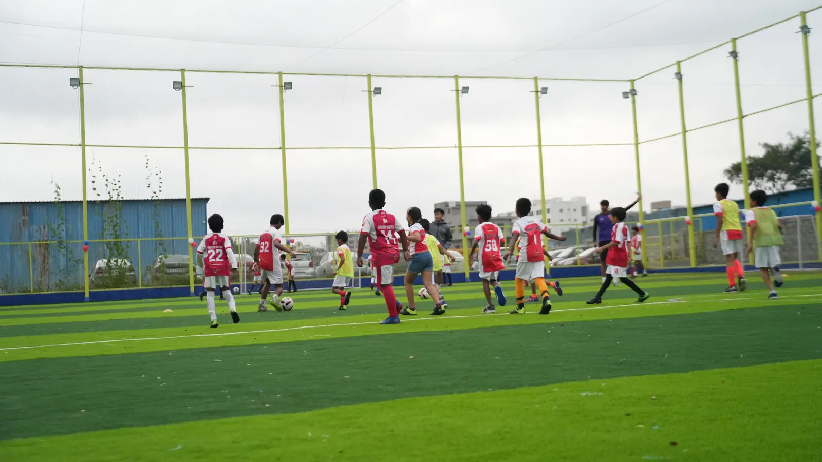 Children training across the floodlit football turf at Coliseo Nice Road