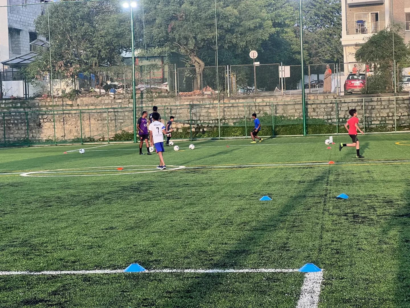 Evening football training on the floodlit turf at Coliseo Noble Residency