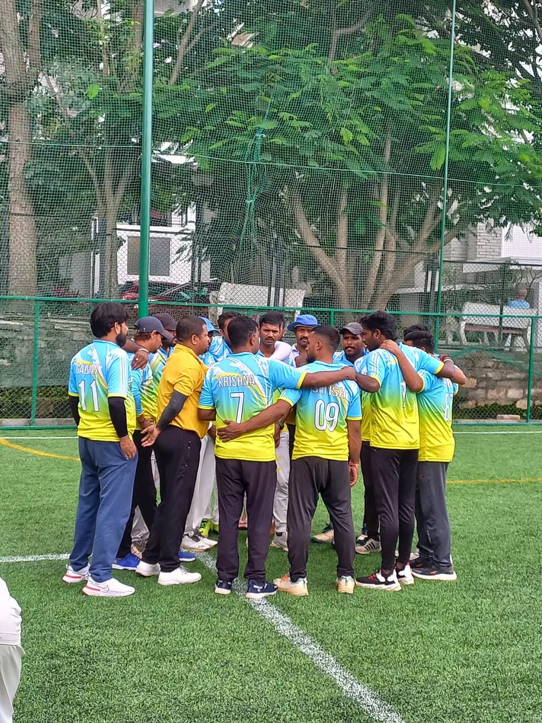 Cricket team in a huddle before a match at Coliseo Noble Residency